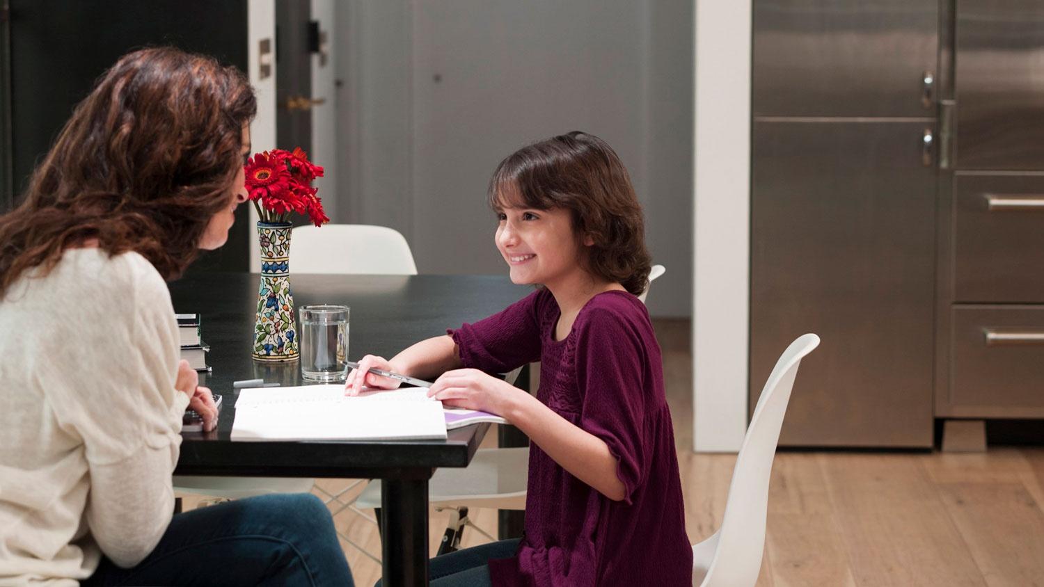 Woman and child doing homework on the kitchen table