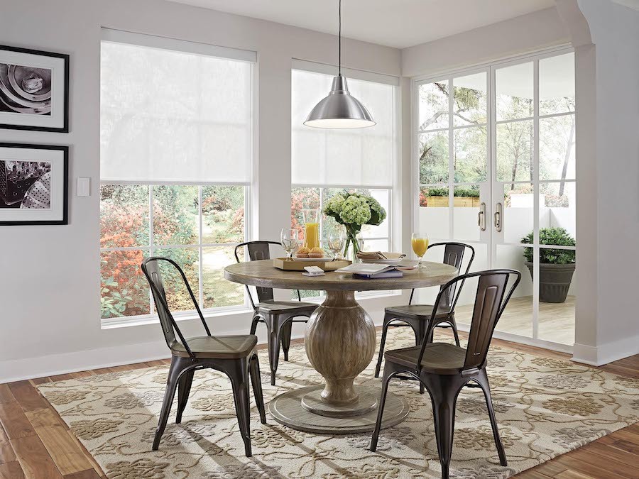 Close up of honeycomb shades on a window in a modern living room.